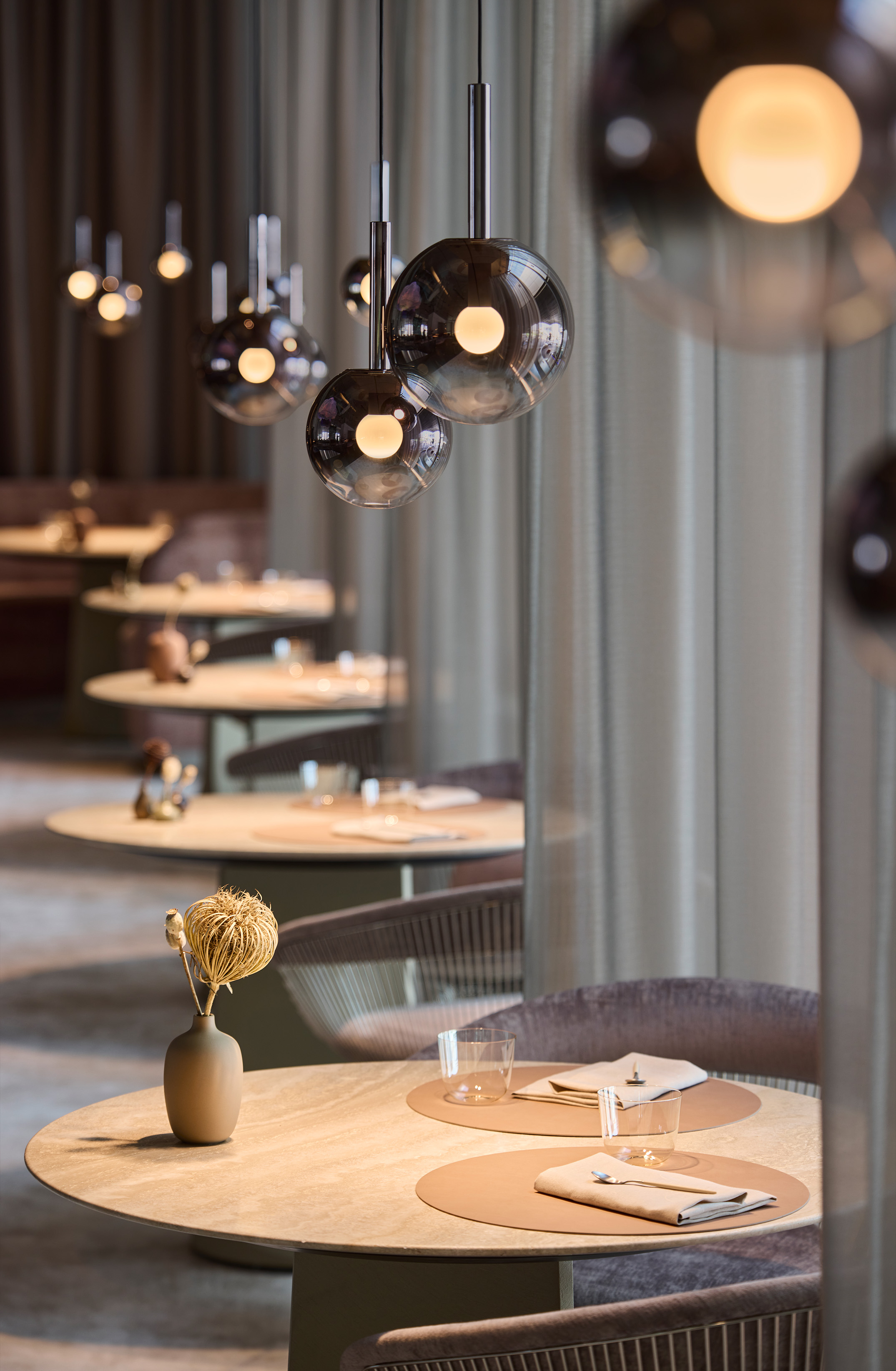 Runde Tische im Restaurant the Cloud von Luna sospeso illuminiert