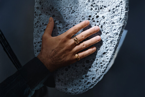 hand touching a rough gray pumice stone