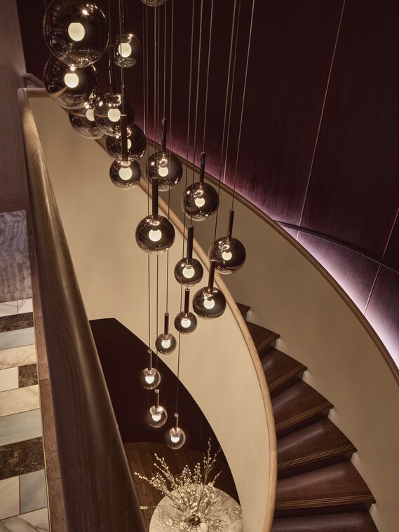 Mehrere Luna sospeso Leuchten erhellen die Wendeltreppe
